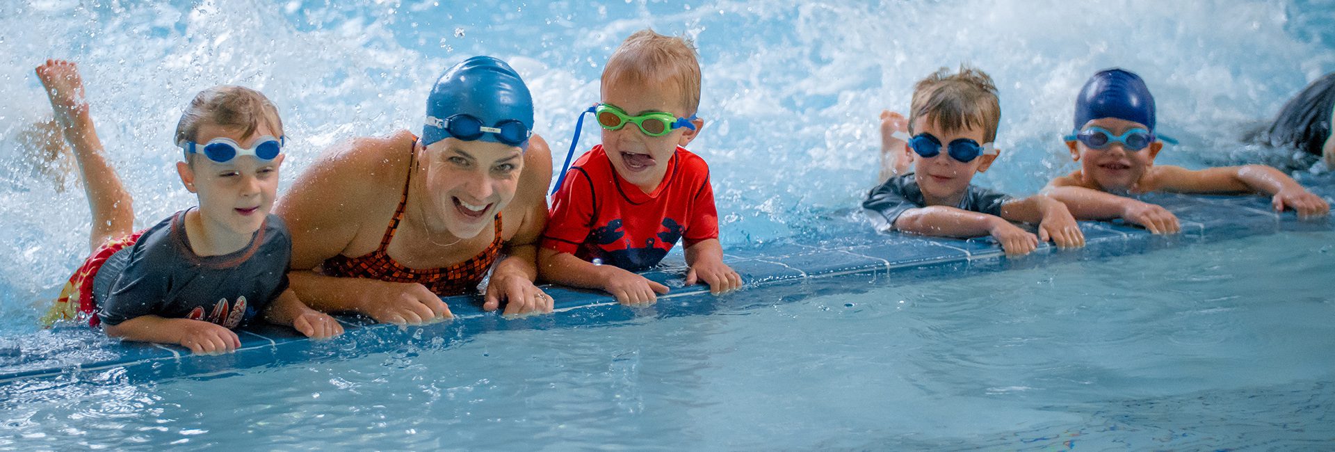 woman and kids smiling in an aquatic center